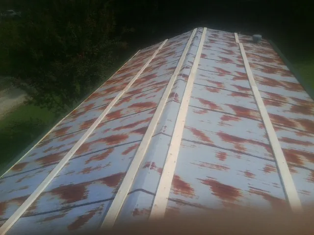 Rusted metal roof panels with new wood purlins before replacement — Storm Damage Roof Repair in Sale Creek by Roofing Brothers