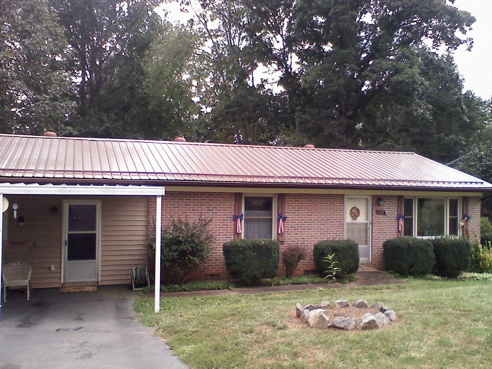 Bronze metal roof and carport on a brick ranch home — Roof Repair work by our crew in Sale Creek